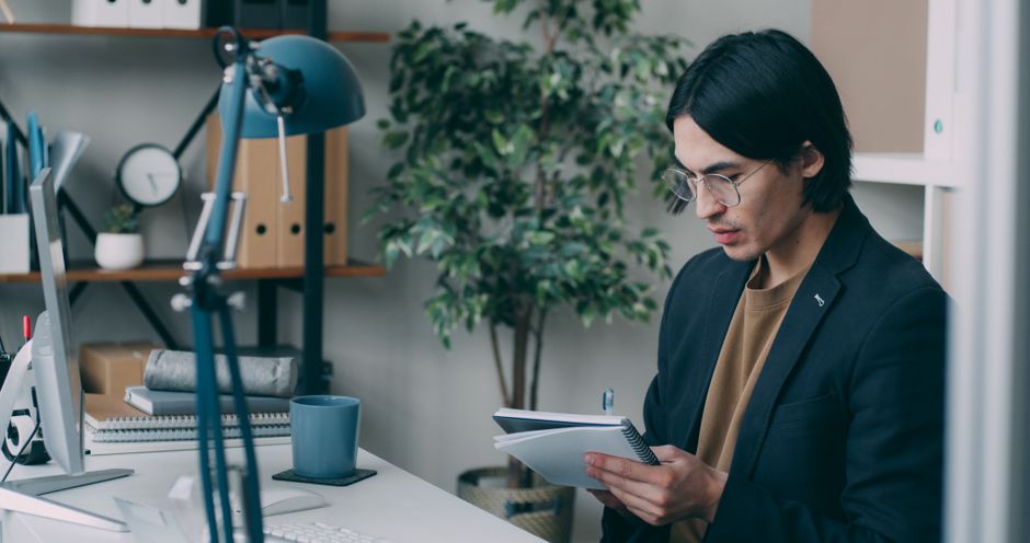 Iemand die opnieuw studeert met een schrift aan een bureau